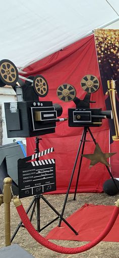 an outdoor movie set up with red carpet and white tent in the background, on display