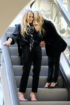 two women walking down an escalator together