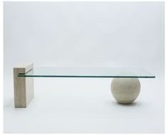 a glass and stone table with a ball on top