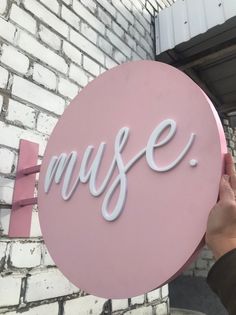 a person holding up a pink sign with the word'music'written on it