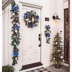 two wreaths on the front door of a house decorated with blue and white decorations