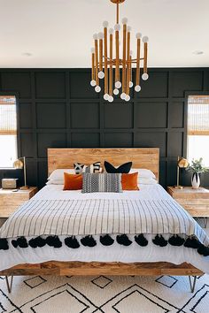 a bedroom with a bed, chandelier and rugs on the floor in front of it