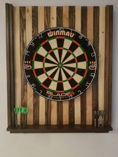 a red and black dart board mounted on the wall next to a shelf with other items