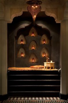 a room that has some lights on the wall and stairs in it with an ornate design