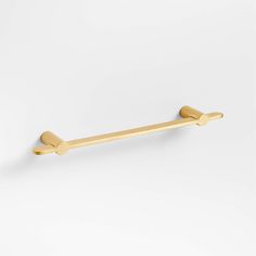 an image of a gold towel bar on a white wall with the handle pointing up