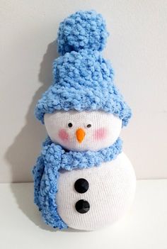 a stuffed snowman with a knitted hat and scarf