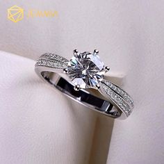 a white gold engagement ring with diamonds on the band and an oval cut diamond in the center