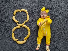 a baby is laying on the floor next to two bananas that are shaped like rings