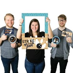 three people holding up signs and smiling at the camera