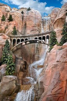 a waterfall with a bridge over it