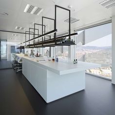 an office space with large windows and white counter tops, overlooking the cityscape