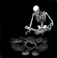 a skeleton sitting on top of a black surface