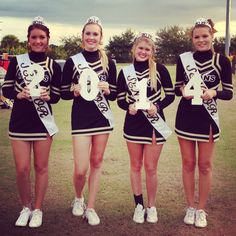 three girls in cheer uniforms holding up their numbers