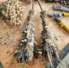 some dried flowers are sitting on a table next to pliers and wire spools