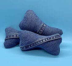 two pieces of blue denim sitting on top of each other in front of a blue background