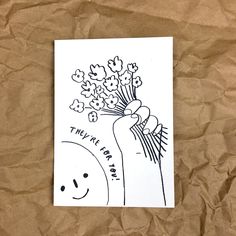 a hand holding flowers on top of a piece of paper with the words, they're happy