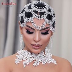 a woman in a wedding dress wearing an elaborate necklace and headpiece with jewels on it