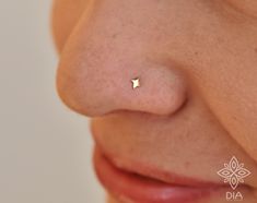 a woman's nose with a tiny gold star piercing on the tip of her nose