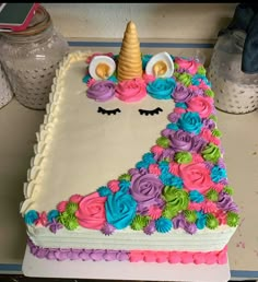 a cake decorated with flowers and a unicorn face