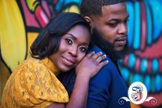 a man and woman hugging in front of a graffiti wall