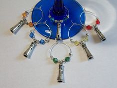 a blue glass plate with silver bells and charms on the rim, hanging from it's side