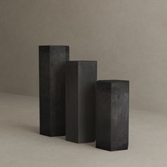 three tall black concrete blocks sitting next to each other