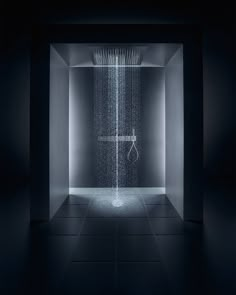 a shower head in the middle of a dark room with water coming out of it