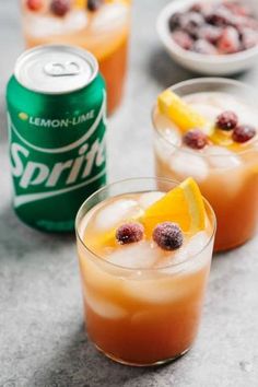 three glasses filled with drinks sitting on top of a table next to a can of soda