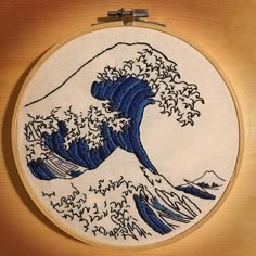 an embroidery project with the great wave in blue and white, on a wooden surface