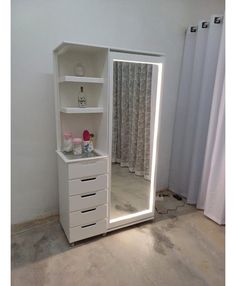 a white cabinet with drawers and a mirror