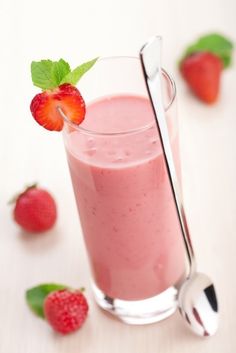 a strawberry smoothie in a glass with a spoon