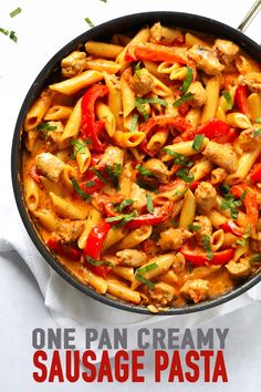 one pan creamy sausage pasta with peppers and chicken in a skillet on a white table