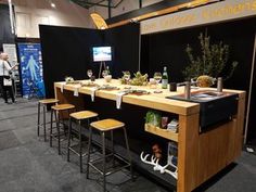 a table with several stools in front of it at a convention or showroom