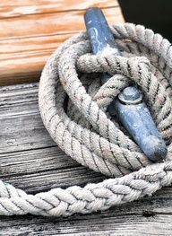 a close up of a rope on top of a wooden dock with a blue handle