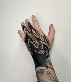 a person's hand with a black and white tattoo on it