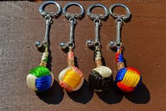 four key chains with different colored balls on them