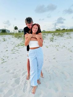 a man and woman hugging on the beach