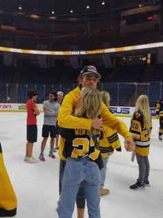 two people hugging each other on an ice rink