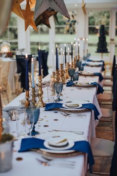 a long table with blue and gold place settings