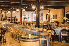 tables and chairs are set up for an event with lights hanging from the ceiling above them