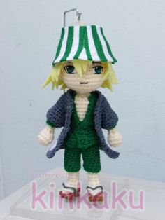 a crocheted doll wearing a green and white hat