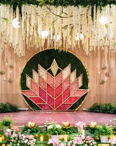 an elaborate floral display is displayed in front of a wall with flowers and greenery