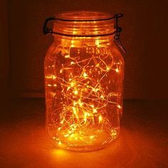 a jar filled with fairy lights sitting on top of a table