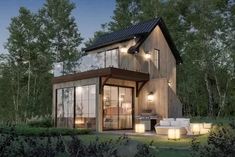 a small house in the woods with lights on it's porch and patio area