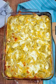 a casserole dish on a wooden table with a knife and fork next to it