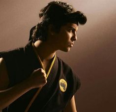 a woman in black shirt holding a yellow frisbee next to her face and arm