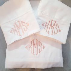 three monogrammed pillow cases on top of each other