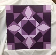 a purple and black painting on a white sheet that looks like it is made out of squares