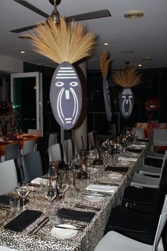 the table is set with black and white place mats, silver napkins, and gold feathers