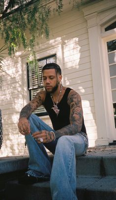 a man with tattoos sitting on the steps